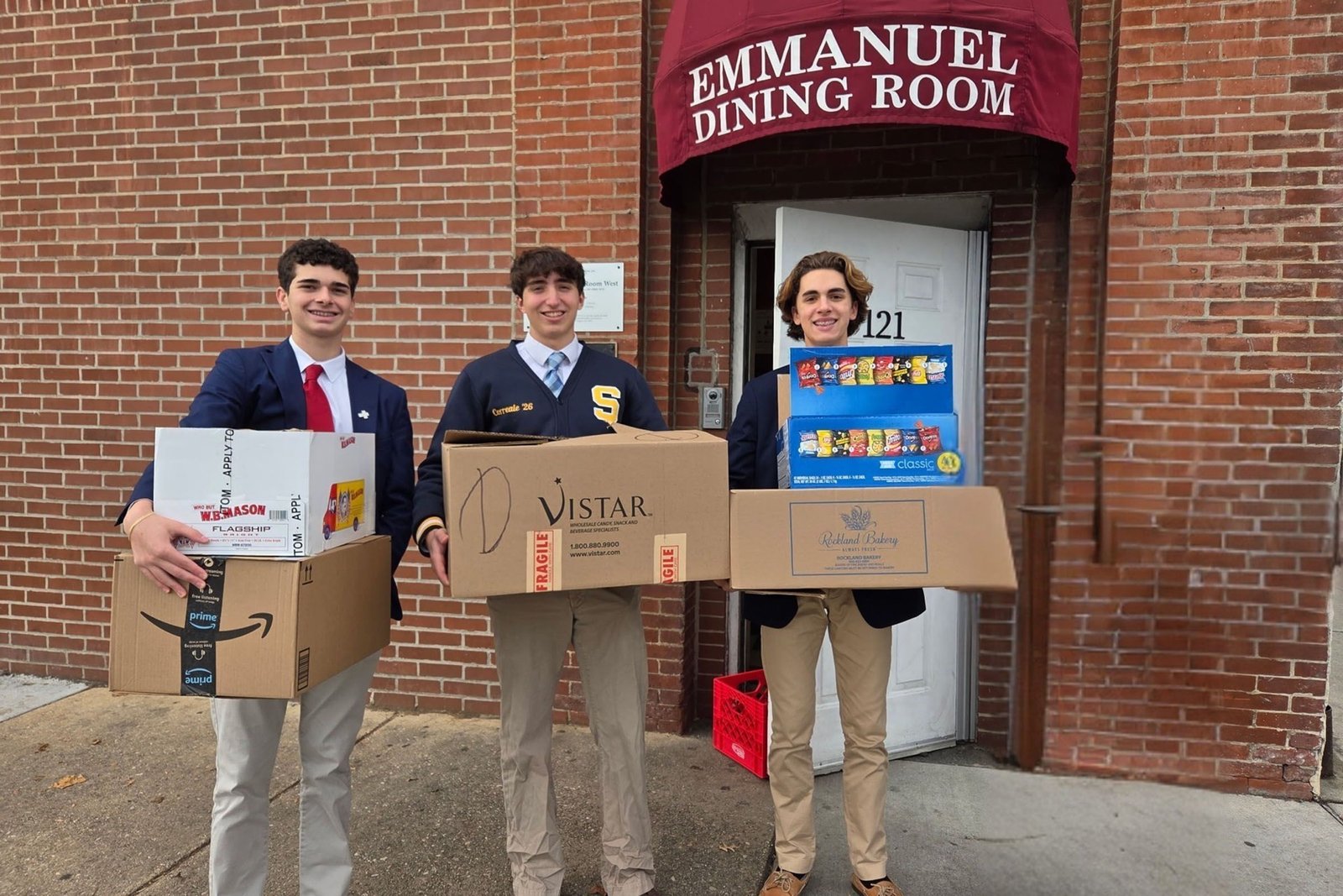 Salesianum students carrying boxes of donated goods for a service drive
